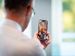bundeskanzler friedrich merz cdu spricht per videocall mit spielern der nationalmannschaft dabei ist jonathan tah auf dem display des smartphones zu sehen