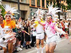 bunt und schrill verkleidete demonstrationsteilnehmer tanzen ausgelassen in wunderschoenen kostuemen bei der csd demontration christopher street day in koeln fuer kulturelle vielfalt der pride bewegung