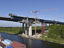 containerschiff faehrt im nord ostsee kanal an der baustelle der rader hochbruecke vorbei nok kielkanal kielcanal schleswig holstein deutschland