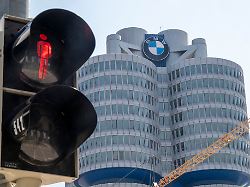 die anzeige einer fussgaengerampel steht vor der bmw firmenzentrale auf rot der autohersteller will weltweit 8 000 jobs abbauen