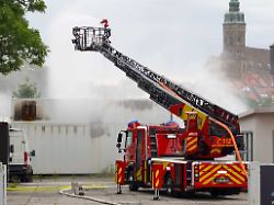 die feuerwehr loescht mit einer ferngesteuerten spritze einen brand in einem batteriespeicher aus sicherheitsgruenden mussten mehrere menschen ihre wohnungen in direkter naehe der anlage verlassen