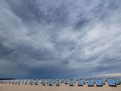 dunkle regenwolken ziehen ueber dem ostseestrand von warnemuende auf