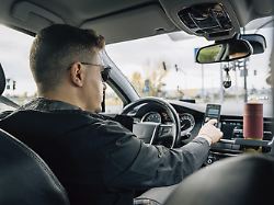 ein mann benutzt beim autofahren ein in der halterung installiertes smartphone modellfreigabe vorhanden
