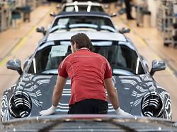 ein mitarbeiter der porsche ag steht in einem lichttunnel in der produktion im stammwerk in zuffenhausen zwischen porsche 911 sportwagen