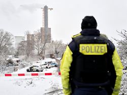 ein polizeibeamter steht an der brandstelle am teltowkanal nach dem brand einer kabelbruecke ist im suedwesten berlins fuer 50 000 haushalte und 2 000 gewerbebetriebe der strom ausgefallen