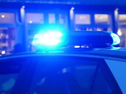 ein streifenwagen der polizei steht mit eingeschaltetem blaulicht an einem einsatzort