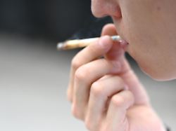 eine mann raucht einen joint am rande der cannabis messe mary jane in berlin