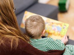 eine junge frau liest einem kleinen jungen aus einem buch vor