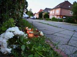 flowers and candles sit in the ground near the scene after a deadly shooting at a youth welfare facility in the northern town of stade germany june 29 2026