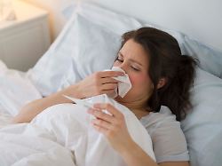 frau liegt mit erkaeltung im bett woman with flu lying in bed modellfreigabe vorhanden