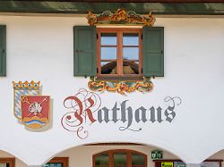 in der ortsmitte von wallgau im isartal steht das rathaus mit seiner praechtig bemalten fassade und der beruehmten lueftlmalerei