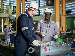 industrial engineers and technicians discussing machine operation while inspecting equipment in a manufacturing factory modellfreigabe vorhanden