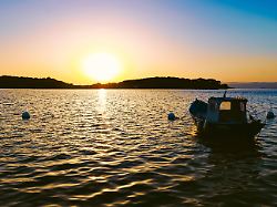 kleines boot im meer in der untergehenden sonne