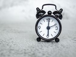 minimales miniaturbild eines einfarbigen weckers das ein sechs uhr konzept fuer den fruehen morgen auf strukturiertem grauem hintergrund zeigt
