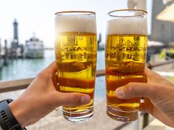 prost am wasser im urlaub zwei kuehle bierglaeser im sommerlicht