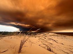 rauchwolken von den waldbraenden suedoestlich des badeortes lacanau ocean hinten r verdunkeln den himmel waehrend sie ueber die duenen am nordstrand hinwegziehen