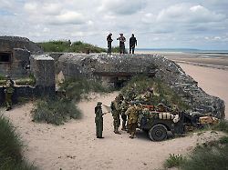reenactors essen in der naehe eines bunkers waehrend der feierlichkeiten zum 80