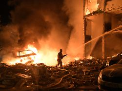 rettungskraefte sind in kiew ukraine damit beschaeftigt einen brand zu loeschen der nach russischen raketenangriffen ausgebrochen ist