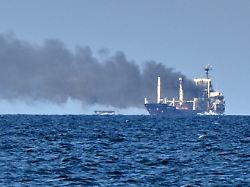 smoke rises from the grain carrier golden leo under the guinea bissau flag after russian missile strike in the black sea close to odesa ukraine sunday july 19 2026 local media reports