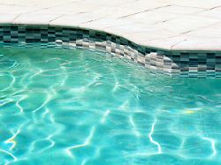 swimming pool with clear turquoise color an edge of outdoor swimming pool with clear turquoise color water and sunny reflections
