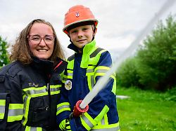 tatjana rueger ortsbrandmeisterin der feuerwehr bad bevensen haelt zusammen mit theo von der kinderfeuerwehr ein strahlrohr