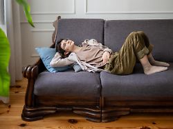 traumhafte faule frau auf sofa allein zu hause verloren in gedanken mit indifferenter stimmung