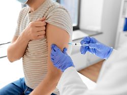 health medicine and pandemic concept female doctor or nurse wearing protective medical mask and gloves with syringe vaccinating male patient at hospital modellfreigabe vorhanden
