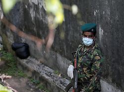 a special task force soldier stands guard near the boundary wall of mahara prison following unrest inside the prison on the outskirts of colombo sri lanka november 30 2020