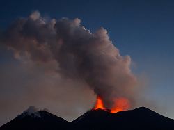 a drone view shows lava being ejected from a crater beneath a plume of volcanic fumes during an eruption of mount etna at dusk in sicily italy august 13 2026