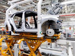 archiv 24 02 2026 niedersachsen emden ein fahrzeug vom typ id 4 faehrt im werk von volkswagen ueber ein band durch die produktionshalle aufnahme mit langer verschlusszeit