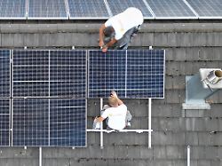 auf einem dach eines privathauses wird eine pv anlage zur stromerzeugung installiert aufnahme mit einer drohne