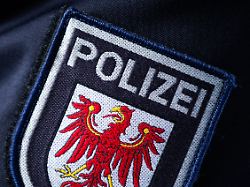 das logo der polizei des landes brandenburg ist auf dem aermel einer polizistin zu sehen