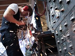 david geisinger auszubildender kunstschmied arbeitet mit einem winkelschleifer in der werkstatt der schmiede lehmann in hamburg altona