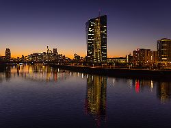 die europaeische zentralbank ezb und die frankfurter skyline die lichter in den bueros der europaeischen zentralbank ezb und der frankfurter skyline leuchten am abend nach sonnenuntergang