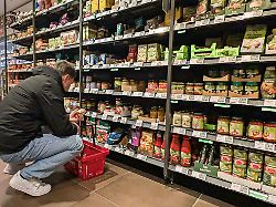 ein kunde betrachtet das angebot an bio fertigprodukten in einem supermarkt