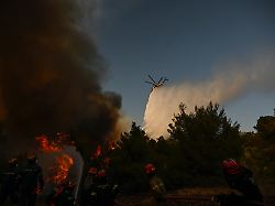 ein loeschhubschrauber wirft bei einem waldbrand in der naehe von porto germeno nordwestlich von athen loeschmittel ueber einen rauchverhangenen wald ab