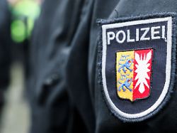 ein logo der polizei mit dem wappen von schleswig holstein ist auf dem arm eines beamten zu sehen 13