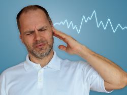 ein mann der an tinnitus oder laermempfindlichkeit leidet waehrend in der naehe seines ohrs eine leuchtende audiowellenform erscheint