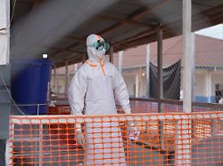 ein mitarbeiter des gesundheitswesens in schutzkleidung schaut in einem ebola behandlungszentrum im osten des landes um sich
