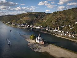 ein schiff faehrt auf dem rhein bei einem niedrigen wasserstand an der burg pfalzgrafenstein vorbei