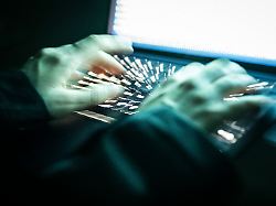 eine person tippt mit den fingern auf einer beleuchteten laptop tastatur