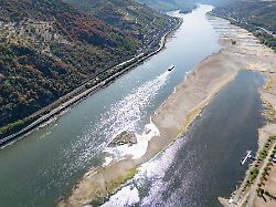 extremes niedrigwasser auf dem rhein laesst bei bacharach den grund des flusses sichtbar werden die binnenschifffahrt ist bereits massiv eingeschraenkt und droht gaenzlich zum erliegen zu kommen