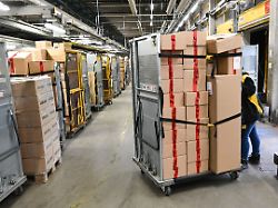 in einem dhl paketzentrum werden container mit paketen transportiert