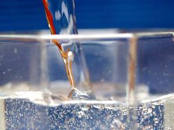 mineralwasser wird in ein wasserglas gegossen