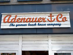 nahaufnahme des hoelzernen adenauer co schildes im beach house stil an der filiale in der koelner einkaufsstrasse breite strasse