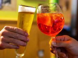 produktion 01 07 2023 berlin in einer bar stossen zwei besucher mit einem glas alkoholfreiem bier und einem glas aperol spritz an