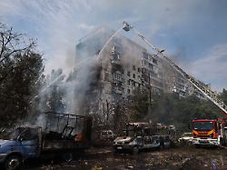 rettungskraefte versuchen einen brand in einem wohnhaus zu loeschen das nach einem russischen luftangriff mit einer luftgelenkten bombe in flammen steht